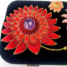 "Bold, colorful OOAK statement clutch bag in black velvet, hand embroidered with large, vibrant exotic flowers. The center of each flower is a semi precious stone, including a large purple amethyst cabochon. Unique and striking - you are certain to be noticed. Measures 8 x 5 inches. Expertly hand embroidered by the most skilled zardozi artisans. Zardozi means \"gold thread\" . It is a centuries old, elaborate art of multidimensional embroidery using gold and silver threads and semi precious and Bohemian Embellished Evening Bag As Gift, Bohemian Embellished Clutch Gift, Bohemian Embellished Clutch As Gift, Bohemian Embellished Clutch For Gift, Multicolor Handmade Evening Bag For Festivals, Handmade Multicolor Evening Bag For Festivals, Handmade Bohemian Clutch For Festive Occasions, Handmade Bohemian Evening Bag For Festive Occasions, Festive Bohemian Handmade Clutch