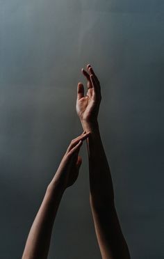 two hands reaching up towards each other