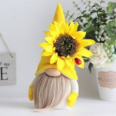 a small doll with a sunflower on its head