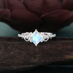 an engagement ring with a white topazte stone and filigreet accents