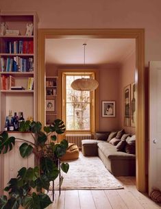 a living room filled with lots of furniture and bookshelves next to a window