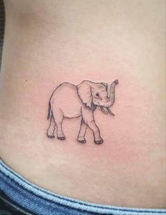 a small elephant tattoo on the side of a woman's rib - up stomach