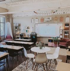 an empty classroom with desks and chairs in front of a whiteboard on the wall