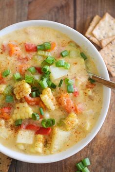 a white bowl filled with soup next to crackers