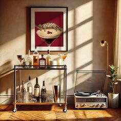 a bar cart with liquor bottles and glasses on it in front of a wall mounted art piece