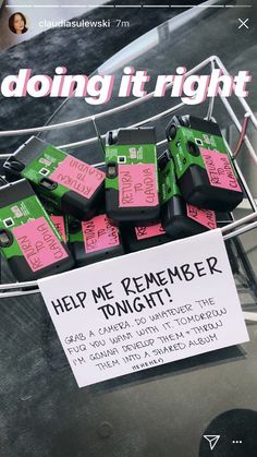 a bunch of pink and green boxes sitting on top of a metal rack next to a sign that says help me remember tonight