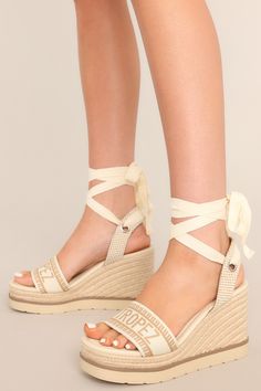 These tan espadrille platform sandals feature a rounded toe, a strap over the top of the foot and around the heel, adjustable self-tie straps around the ankle, and a wedged heel. Trendy Espadrille Wedge Sandals, Trendy Espadrille Wedge Heels, Straw Wedge Sandals With Flat Heel, Straw Wedge Sandals With Flat Heel And Platform, Straw Platform Wedge Sandals, Trendy Espadrille Platform Wedge Sandals, Beige Platform Espadrille Sandals, Beige Platform Espadrille-style Sandals, Beige Platform Sandals With Espadrille Material