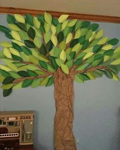 a tree made out of paper sitting on top of a wall