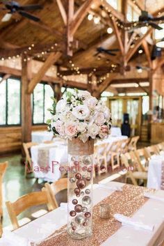 a vase with flowers on top of a table in a room filled with tables and chairs