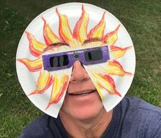 a man is wearing a paper plate with glasses on his face and the image of a fire