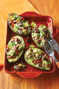 stuffed peppers with meat and veggies on a red plate next to a fork