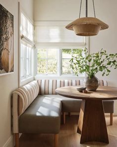 a wooden table sitting under a window next to a bench