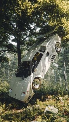 a car that is upside down in the woods