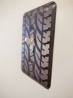 a wall mounted light switch plate with a tire print design on it's side