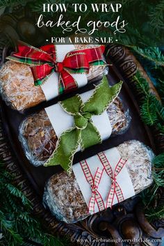 christmas treats wrapped in paper and tied with bows on a tray surrounded by pine branches