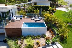 an aerial view of a house with a swimming pool in the yard and landscaping around it