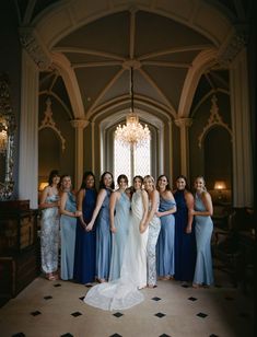 a group of women standing next to each other in front of a chandelier