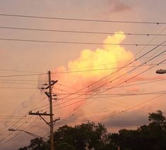 the sun is setting behind power lines and telephone poles