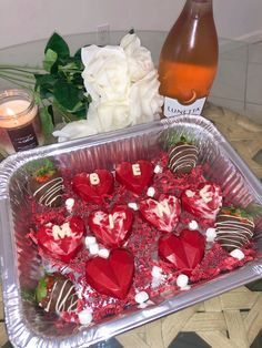 chocolate covered strawberries are arranged in a heart - shaped tray next to a bottle of wine