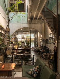 the interior of a coffee shop with people sitting at tables