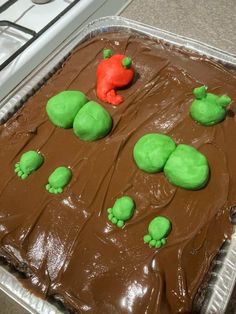 a cake with green frosting and red icing on the top is in a pan