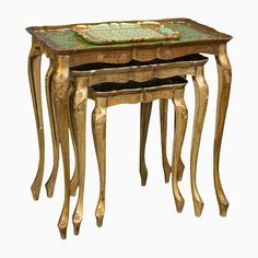 three gold and green nesting tables with one sitting on top of the other, each holding a glass tray