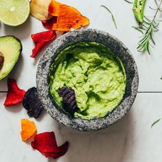 guacamole in a bowl surrounded by cut up vegetables