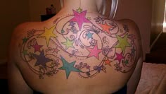 a woman's back with colorful stars and swirls on it