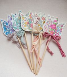 six flowered hair clips are lined up in a row