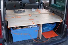 the back end of a van with its cargo compartment open and parts labeled in red