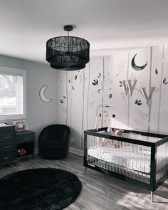 a baby's room with a black crib and white walls