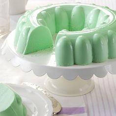 a green cake sitting on top of a white plate