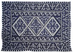 an embroidered blue and white cloth with two squares on the front, one in the middle