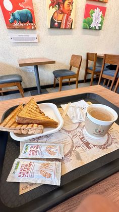 a tray that has some food on top of it and a cup of coffee in front of it