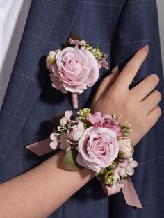 two pink flowers are on the arm of a man in a suit