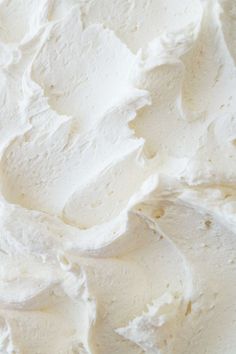 a close up view of white frosting on a cake