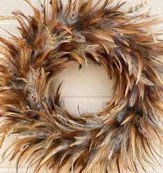 a wreath made out of feathers hanging on a door