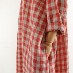 a red and white checkered shirt with a wooden dummy sticking out of it's chest