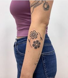 a woman with a flower tattoo on her left arm and the other half of her arm