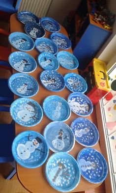 blue plates with snowmen on them sitting on a table