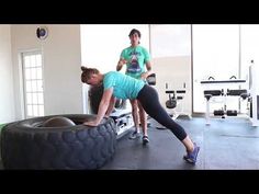 two people doing exercises in a gym with an exercise tire on the floor and another person standing behind them