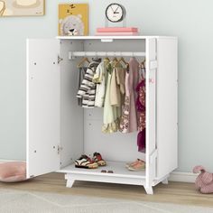 a child's white wardrobe with clothes hanging on hooks