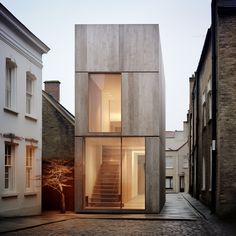 the house is made out of concrete and has stairs leading up to the second floor