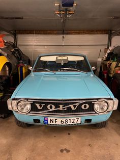 an old blue car is parked in a garage