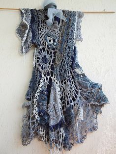 there is a crocheted dress hanging on the wall