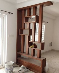 a room that has some shelves on the wall and a trash can next to it