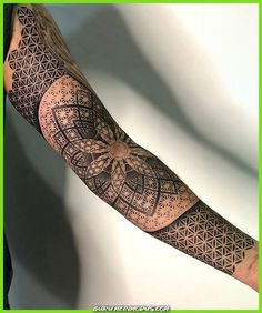 a man's arm with an intricate tattoo design on the forearm and hand area