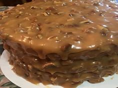 there is a large cake covered in caramel icing on the plate and ready to be eaten