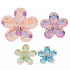 three different colored flower shaped glass beads on a white background with clippings to the side