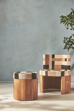 two wooden stools sitting next to a potted plant